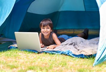 Image showing Child, boy and happy with laptop in tent for camping, social media and online movie with portrait in nature. Person, face and kid with smile outdoor on grass for gaming, vacation relax or holiday fun