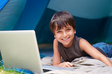 Image showing Kid, boy and happy with laptop in tent for camping, social media and online movie with portrait in nature. Person, face and child with smile outdoor on grass for gaming, vacation relax or holiday fun