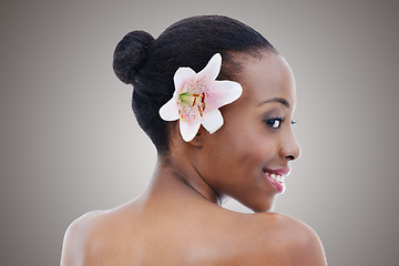 Image showing Flower, skincare and smile of black woman profile in studio on gray background for cosmetic wellness. Aesthetic, beauty or floral dermatology and back of happy young person at spa with orchid plant