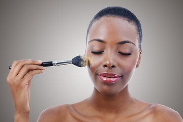Image showing Brush, makeup and black woman, face and beauty with foundation for cosmetics and wellness isolated on grey background. Shine, cosmetology and tools to apply powder, skin glow and shimmer in studio