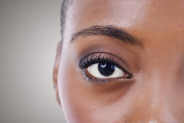 Image showing Half, face and eye of black woman closeup for beauty or dermatology in gray background mockup. Skincare, portrait and African model with natural glow from makeup, cosmetics or facial in studio