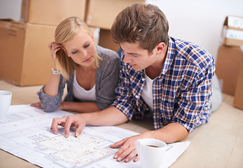 Image showing Couple, planning and house blueprints with moving boxes for home renovation, floor plan or property investment. Man, woman and thinking development for real estate design or mortgage, buy or coffee