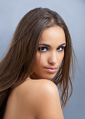 Image showing Woman, portrait and hair in natural beauty, skincare or cosmetics on a blue studio background. Face of young attractive female person, brunette or model with makeup for facial treatment or haircare