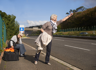 Image showing Travel, highway and senior friends hitchhiking together for adventure, escape or journey in retirement. Road, smile or happy and hand gesture with elderly women on sidewalk for holiday or vacation