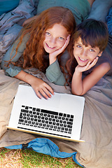 Image showing Children, portrait and smile with laptop for camping in tent, streaming or online movie with aerial view in nature. Family, face and siblings or happy outdoor on grass for trip, relax and holiday