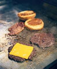 Image showing Cooking burgers on hot grill