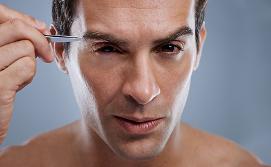 Image showing Man, portrait and tweezers for eyebrows or grooming for face clean, hygiene or grey background. Male person, pluck and hair removal for healthy morning routine or studio, treatment or mockup space