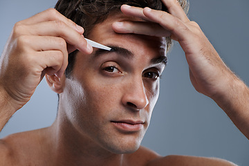 Image showing Man, portrait and tweezers for eyebrows or pluck for face clean, hygiene or grey background. Male person, grooming and hair removal for healthy morning routine or studio, treatment or mockup space