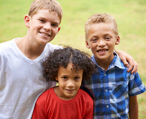 Image showing Boys, friends and portrait or happy outdoor in summer with confidence, pride or diversity in nature. Children, face or smile on grass field with embrace for friendship, care and support on playground
