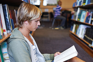 Image showing Reading book, learning or student in library at university, college or school campus for education growth. Bookshelf, floor or smart man with scholarship studying knowledge, research or information