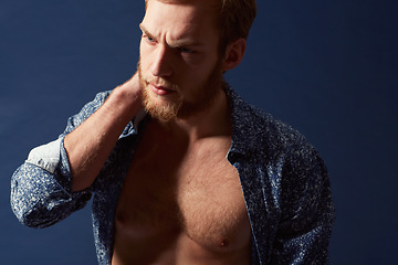 Image showing Fashion, body or model with muscle in studio on a blue background wearing an open unbuttoned shirt. Thinking, chest or handsome male person posing on color wall for masculine style, health or fitness