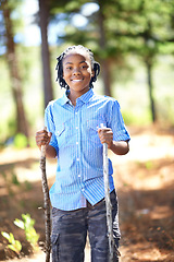 Image showing Happy black child, portrait and hiking with sticks for walking, adventure or outdoor exploring in forest. Young African male person or kid smile for trekking, trip or holiday in woods or nature