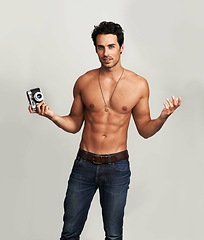 Image showing Camera, shirtless and portrait of man in a studio with art, creative and photography career. Confused, doubt and young male photographer from Canada with dslr equipment isolated by gray background.