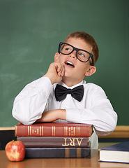 Image showing Boy child, books and classroom with thinking, ideas or information for knowledge, solution and school. Student, problem solving and brainstorming for education, learning or development with glasses