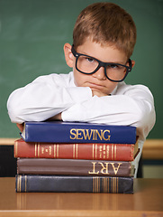 Image showing Frustrated boy child, books and portrait in classroom for knowledge, information and studying at academy. Student kid, learning and education with glasses, angry and stress for assessment at school