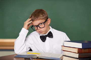 Image showing Student child, stress and portrait with books, classroom and anxiety for exam, assessment and studying for knowledge. Boy kid, notebook and learning for education, development and glasses at table