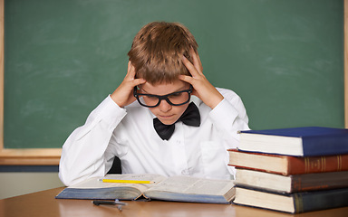 Image showing Boy child, stress and thinking with books, classroom and anxiety for exam, assessment and studying for knowledge. Student kid, notebook and learning for education, development and reading at table