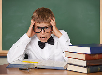 Image showing Boy child, stress and portrait with books, classroom and anxiety for exam, assessment and studying for knowledge. Student kid, notebook and learning for education, development and glasses at table