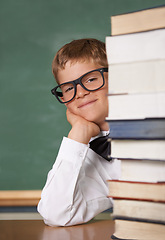 Image showing Child, school portrait and stack of books for education, language learning and knowledge in classroom. Happy face of kid, boy or student in glasses with textbook, literature and library resources