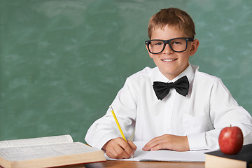 Image showing Young boy, portrait and writing at school for learning, education or knowledge with green chalk board. Face of male person, smart child or teenager smile with books for academic literature in class