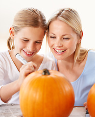 Image showing Child, mother and smile for drawing on pumpkin, craft and celebrate halloween party at home. Happy girl kid, mom or family writing with pen marker on vegetable, holiday lantern or creative decoration