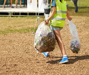 Image showing Woman, cleaning and event outdoor garbage for recycle cans at festival for sustainable eco friendly, nature environment on campground. Female person, plastic bag at social party, helping in forest