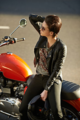 Image showing Motorcycle, street and woman in city with sunglasses for travel, transport or road trip as rebel. Fashion, leather and model with attitude on classic or vintage bike for transportation or journey