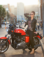 Image showing Bike, fashion and woman in city with sunglasses for travel, transport or road trip as rebel. Leather, asphalt and model with attitude on classic or vintage motorcycle for transportation or journey