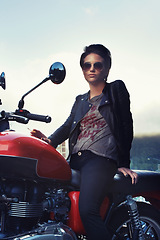 Image showing Motorcycle, leather and rebel woman in city with sunglasses for travel, transport or road trip. Fashion, evening and person with attitude on classic or vintage bike for transportation or journey