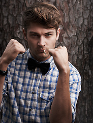 Image showing Fight, smoking and portrait of man in outdoors for challenge, strong and boxing. Cigarette, hipster and anger with face of male person and hands up in nature for combat, cool and trendy style