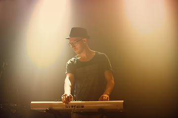 Image showing Music, concert and man playing keyboard for performance at night with glasses in entertainment. Musician, artist and instrument for party and culture song at nightclub on new years eve at festival