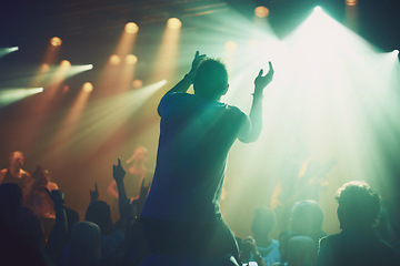 Image showing Back, dark concert and person clapping at music performance and having fun. Social event, party and excited fan cheering for live show culture on new year eve with a crowd at the disco celebrating