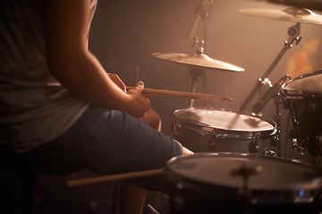 Image showing Hands, drummer and musician in performance at rock concert, music festival on stage and band. Closeup, artist and playing on drumstick for entertainment, sound or rehearsal on percussion instrument