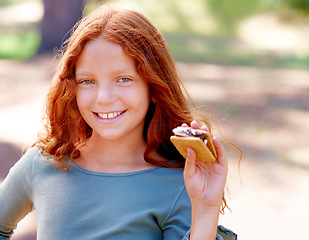 Image showing Young girl, camping and smores in portrait in nature, happiness and hungry for sweet snack in woods. Red hair, child and happy face by sugar candy for eating, relax and outdoor on holiday adventure