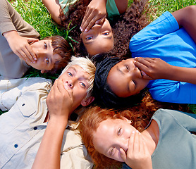 Image showing Shock, secret and group of children outside in nature for holiday and leisure adventure. Joke, cover mouth and diverse kid best friends with gossip lying on grass for vacation for natural fun