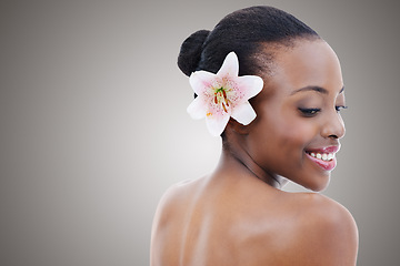 Image showing Skincare, beauty and black woman with flower on gray background for wellness, cosmetics and makeup. Dermatology mockup, salon and person smile for aesthetic, natural products and facial in studio