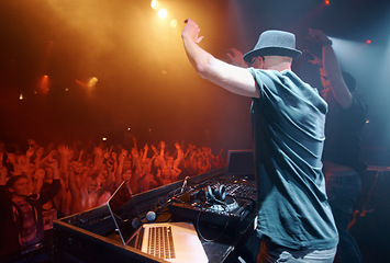 Image showing Concert, party or man in music festival to dj for performance or celebration with fans or audience. Stage, night or musician with hand up or crowd of people at a rave event with turntable technology