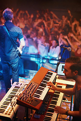 Image showing Band, performance and fans at stage for concert with person on piano and guitar. Music festival, crowd and people with talent playing for audience in theater or club at night with musician in light