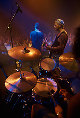 Image showing Drummer, musician and band at stage for concert, performance and crowd at night. Music festival, talent and people playing for audience in theater or club with instrument, light and creative energy