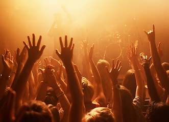 Image showing Music, concert and group of fans for performance with lighting equipment at party or rave. Event, entertainment and audience at festival, disco or club with energy for crowd for song at venue.
