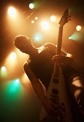 Image showing Concert, band and guitar with man on stage for music, performance and rock show. Event, spotlight and energy with male musician playing instrument at festival club for rave, disco and celebration