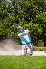 Image showing Senior, sand and man playing golf in pit, lawn or green grass or field for sports, swing or shot on course. Mature male person, golfer or player hitting difficult ball for game or point in nature