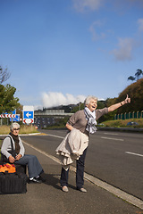 Image showing Women, road and hitch hiker for travel in retirement, lift and friends in city with bags for adventure. Senior ladies, thumbs up and happy by roadside with hand gesture and stop transport to commute