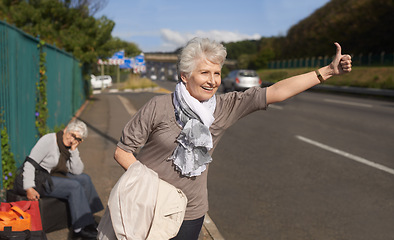 Image showing Women, road and hitch hiker for lift in retirement, travel and friends in city with bags for adventure. Senior ladies, thumbs up and happy by roadside with hand gesture and stop transport to commute