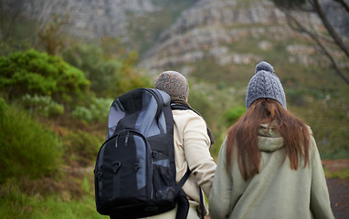 Image showing Outdoor, hiking and couple in mountain, holding hands and walking with backpack, nature and bonding together. Forest, adventure and trekking in path, field and exercise for fitness and travel
