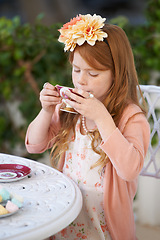 Image showing Girl, child and drinking tea in garden with party for birthday, celebration and playing outdoor in home. Person, kid and porcelain cup in backyard of house with dress up, beverage and role play fun