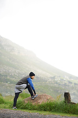 Image showing Fitness, nature and a man stretching for a run, exercise or morning workout in the morning. Thinking, sports and a male runner or athlete with a warm up on the road for the start of training