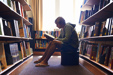 Image showing Reading book, relax or student in library at university, college or school campus for education growth. Bookshelf, learning or young man with scholarship studying knowledge, research or information