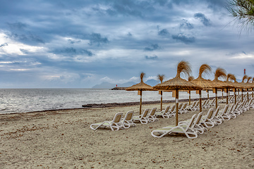 Image showing Can Picafort Beach with straw umbrellas and sun loungers, Can Picafort, Balearic Islands Mallorca Spain.