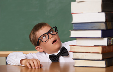 Image showing Child, surprise and stack of books in classroom for education, language learning and knowledge with wow for studying list. Kid or student with glasses and shocked for school literature and textbook